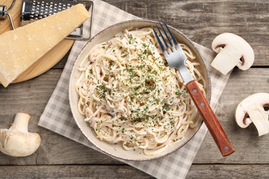 Photo of Delicious pasta with mushroom sauce and parmesan cheese on wooden table, flat lay