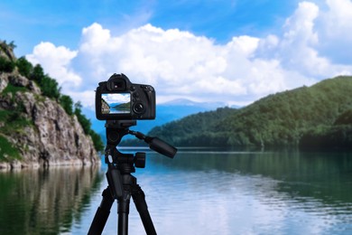 Image of Taking photo of beautiful river and mountains with camera mounted on tripod