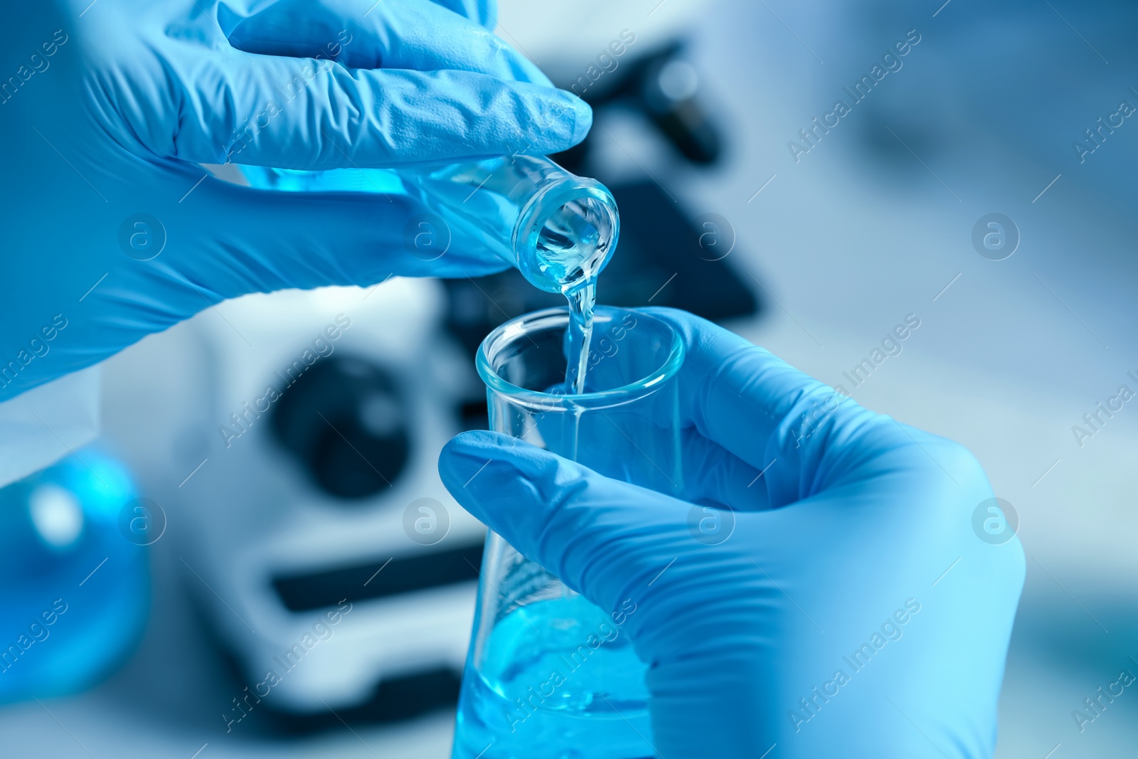 Photo of Scientist working with flasks in laboratory, closeup