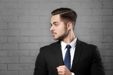 Portrait of young man with beautiful hair on brick wall background