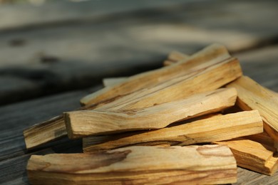 Photo of Palo santo sticks on wooden table outdoors