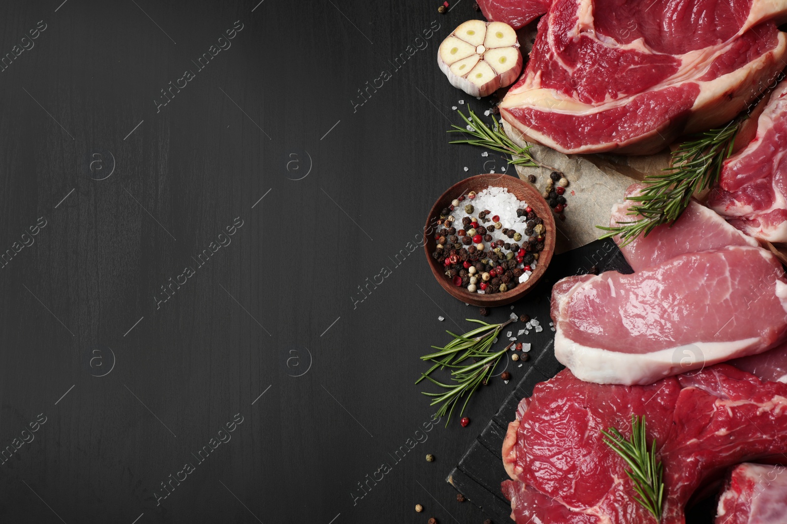 Photo of Flat lay composition with fresh meat on dark table. Space for text