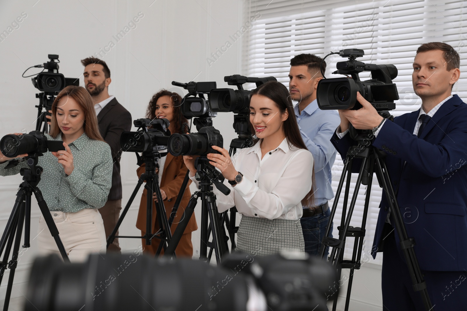 Photo of Group of journalists with cameras waiting for official person indoors