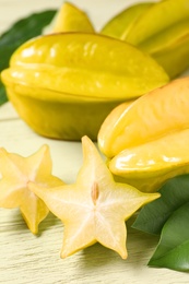 Photo of Delicious carambola fruits on yellow wooden table