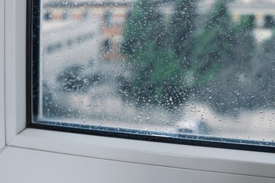 Wet window on rainy day, closeup. View from inside