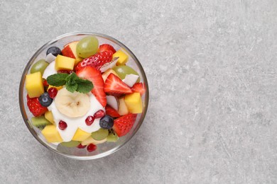 Photo of Delicious fruit salad on light grey table, top view. Space for text