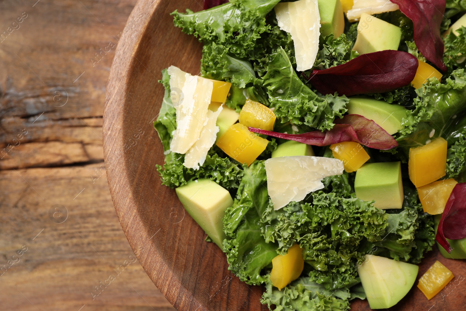 Photo of Delicious kale salad served on wooden table, top view