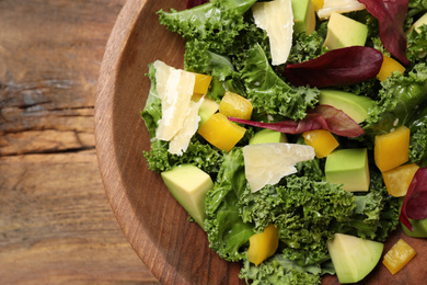 Photo of Delicious kale salad served on wooden table, top view