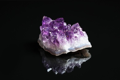 Photo of Beautiful purple amethyst gemstone on black background