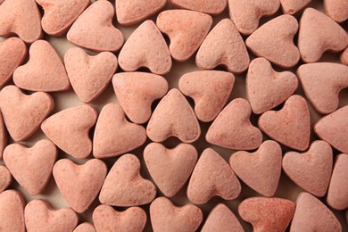 Photo of Many heart shaped vitamins for pets on beige background, flat lay