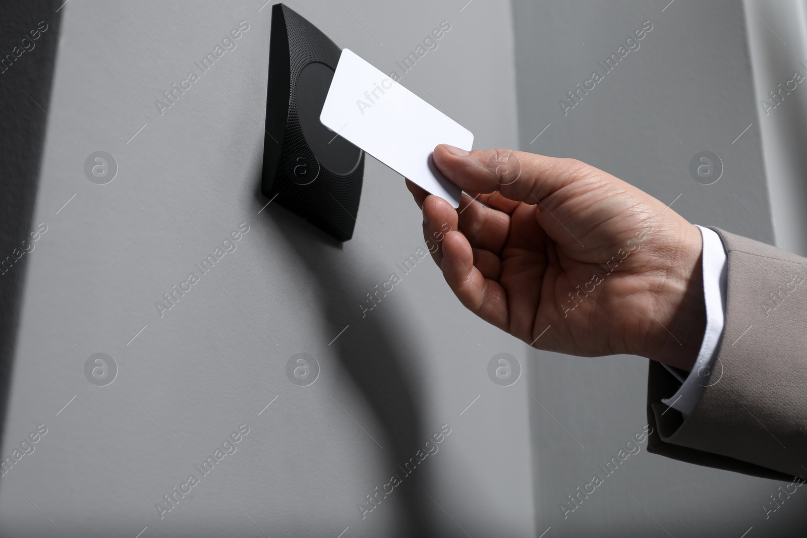 Photo of Man opening magnetic door lock with key card, closeup. Home security