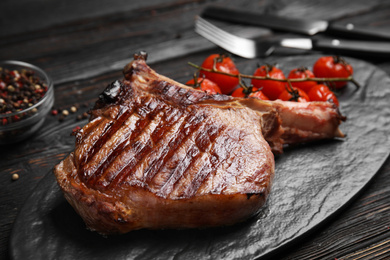 Photo of Delicious beef steak served on black wooden table, closeup