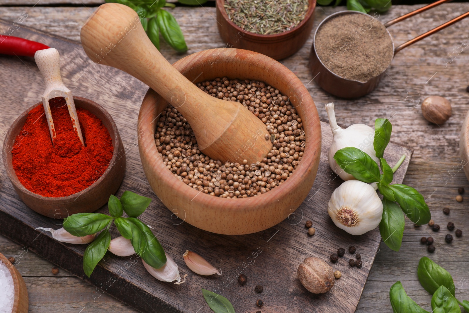 Photo of Mortar with pestle and different spices on wooden table, above view