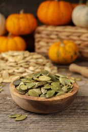 Bowl with pumpkin seeds on wooden table