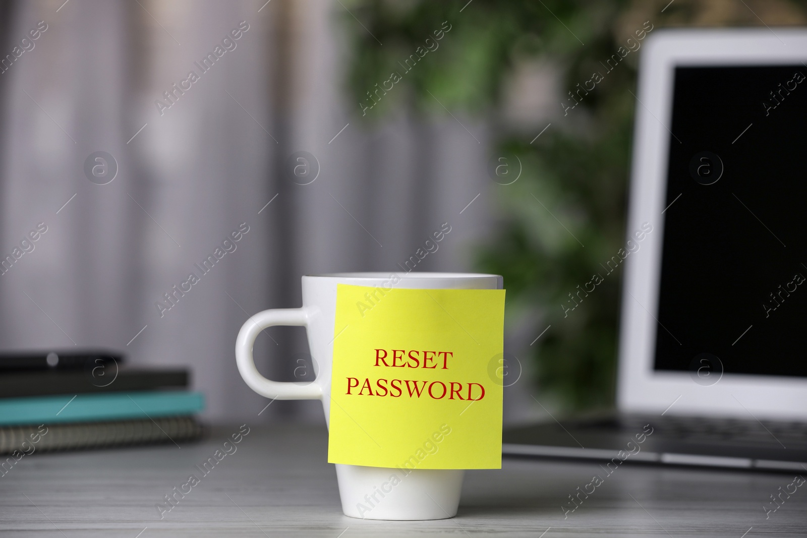 Image of Sticky note with phrase Reset Password on cup indoors