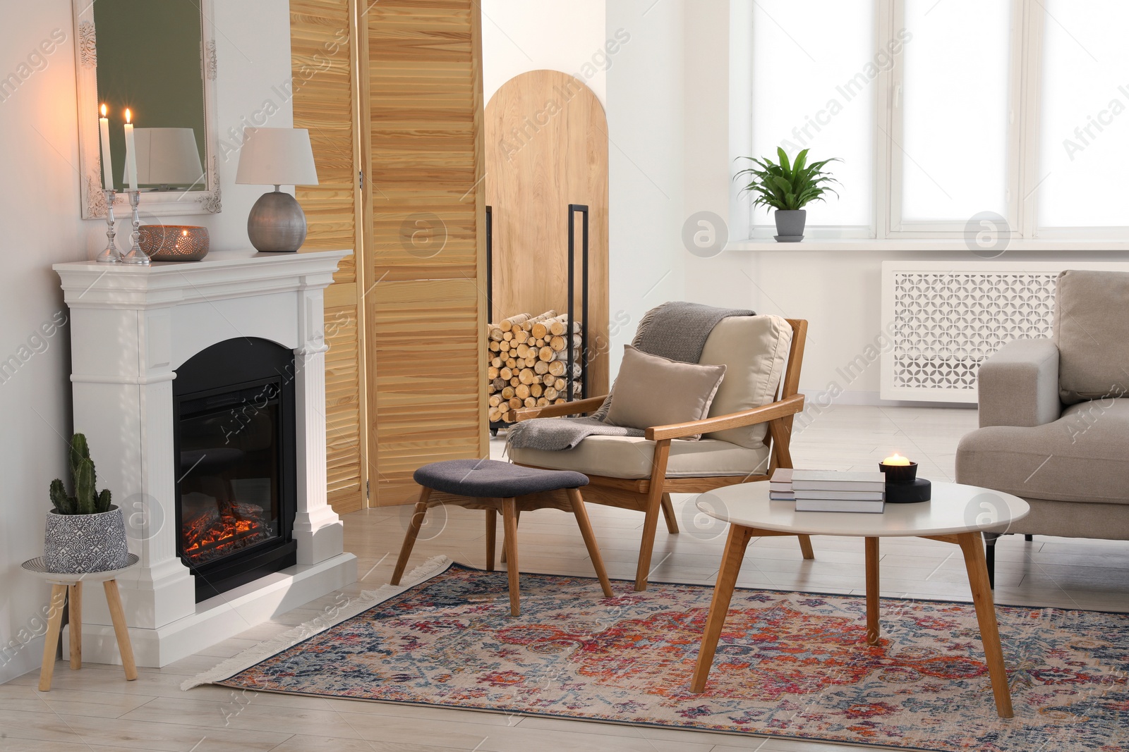 Photo of Stylish living room with beautiful fireplace, armchair, ottoman and table. Interior design