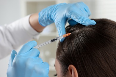 Photo of Trichologist giving injection to patient in clinic, closeup