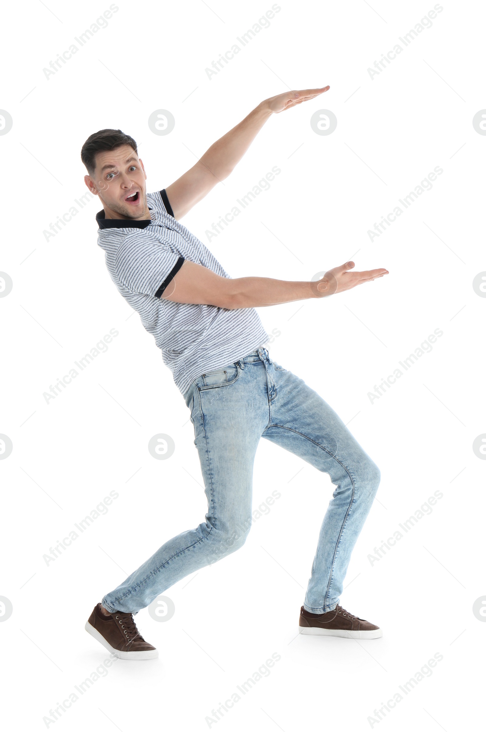 Photo of Emotional man in casual clothes holding something on white background