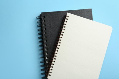 Photo of Notebooks on black background, top view. Space for text