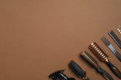 Photo of Flat lay composition with modern hair combs and brushes on brown background. Space for text