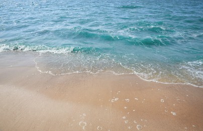 Tropical sandy beach washed by sea on sunny day