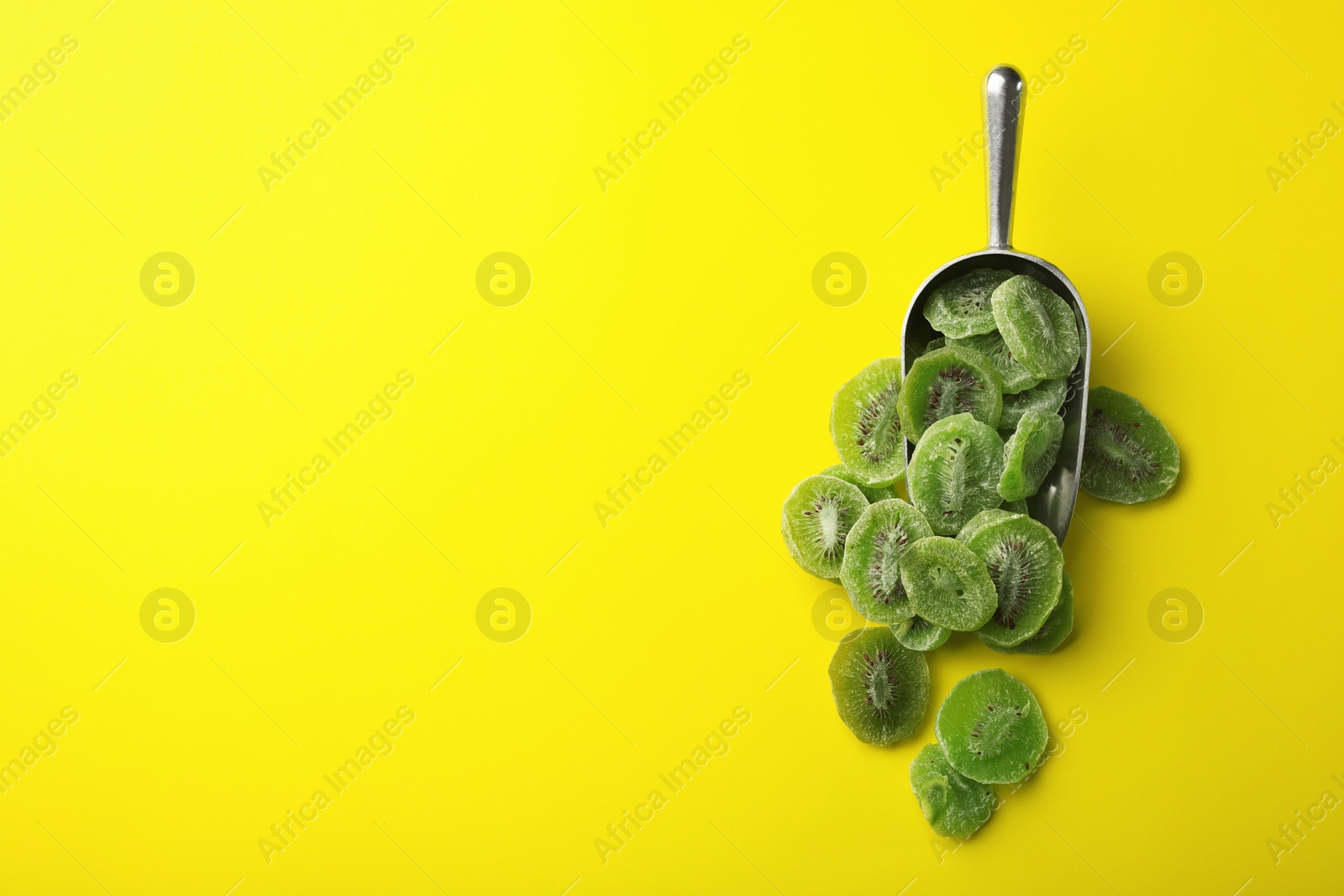 Photo of Scoop of dried kiwi on color background, top view with space for text. Tasty and healthy fruit