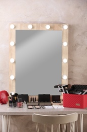 Photo of Dressing table with different makeup products and accessories in room interior