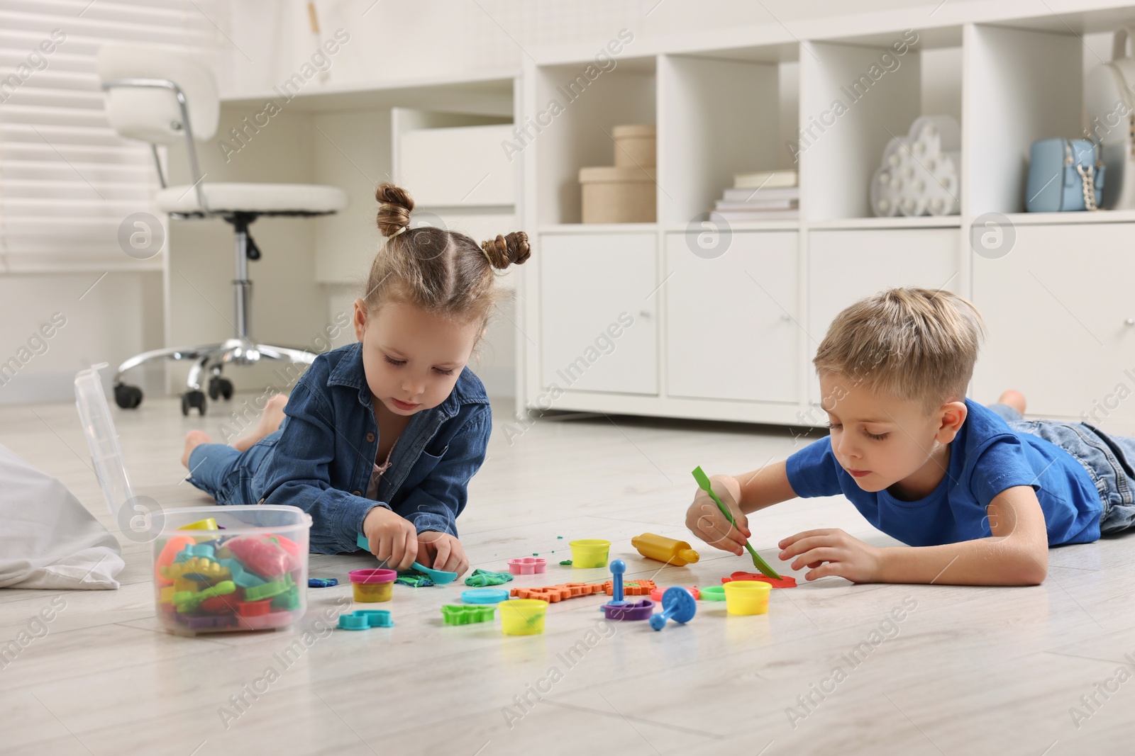 Photo of Cute little children playing on warm floor at home. Heating system