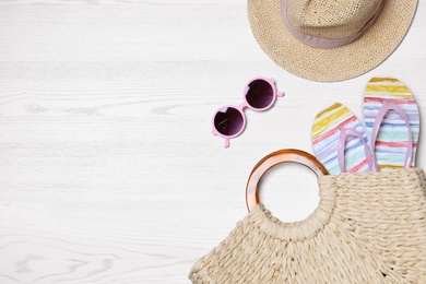 Photo of Flat lay composition with beach bag and accessories on white wooden background, space for text