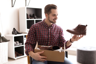 Young man choosing shoes in store