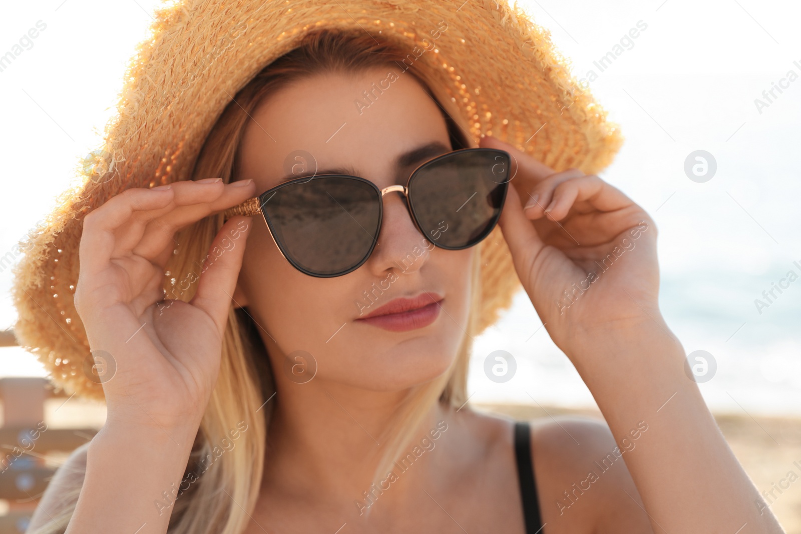 Photo of Beautiful woman wearing sunglasses outdoors on sunny day, closeup