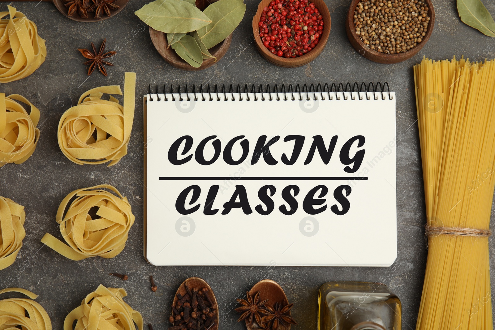 Image of Notebook with inscription Cooking Classes, raw pasta and spices on grey table, flat lay