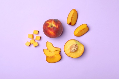 Flat lay composition with sweet juicy peaches on lilac background