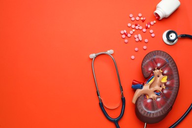 Photo of Kidney model, pills and stethoscope on orange background, flat lay. Space for text