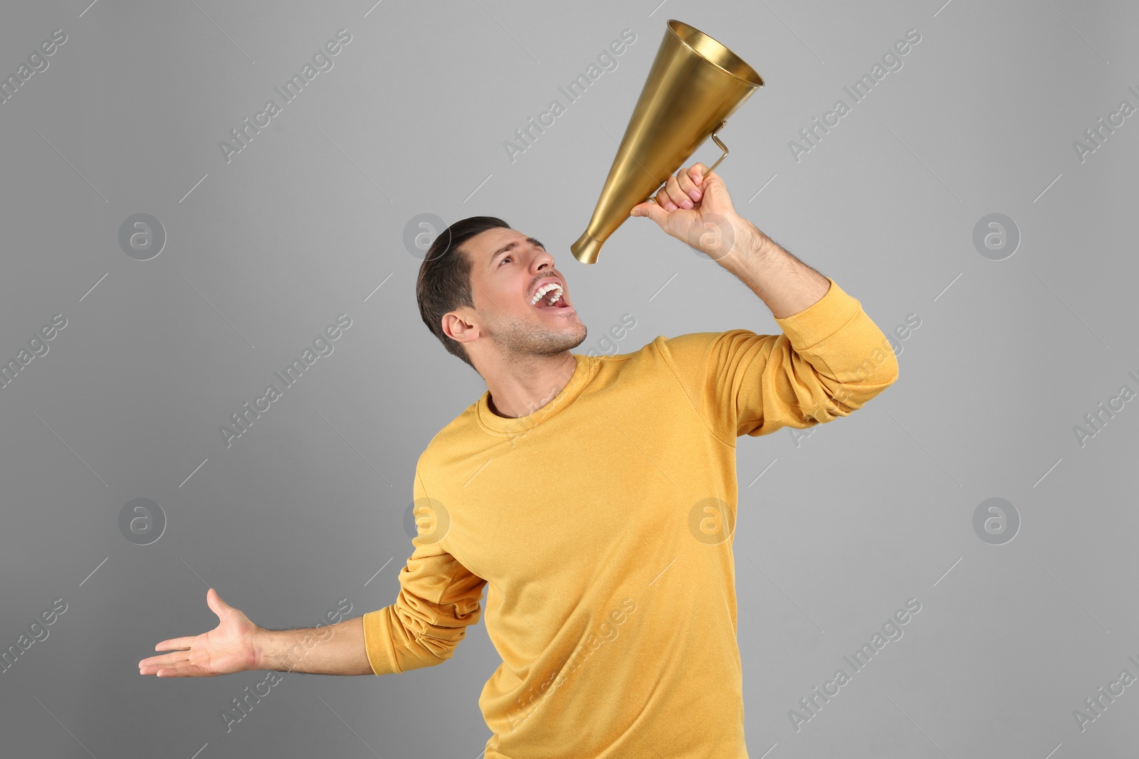 Photo of Handsome man with megaphone on grey background