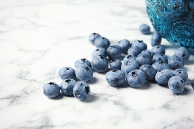 Photo of Fresh and juicy blueberries on marble table
