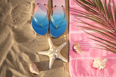 Photo of Flat lay composition with stylish beach accessories on sand
