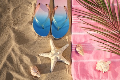 Flat lay composition with stylish beach accessories on sand