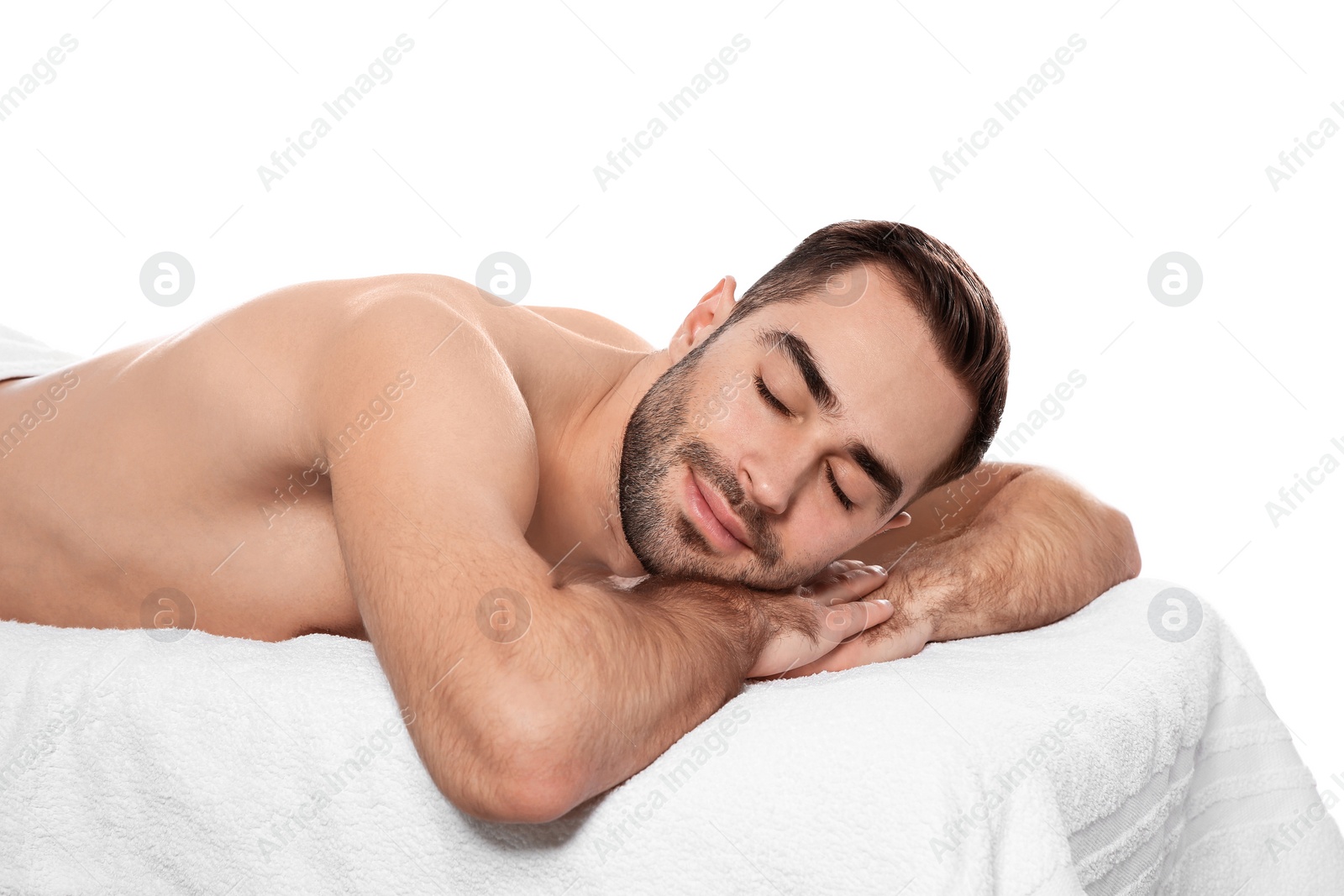 Photo of Handsome man relaxing on massage table against white background. Spa service