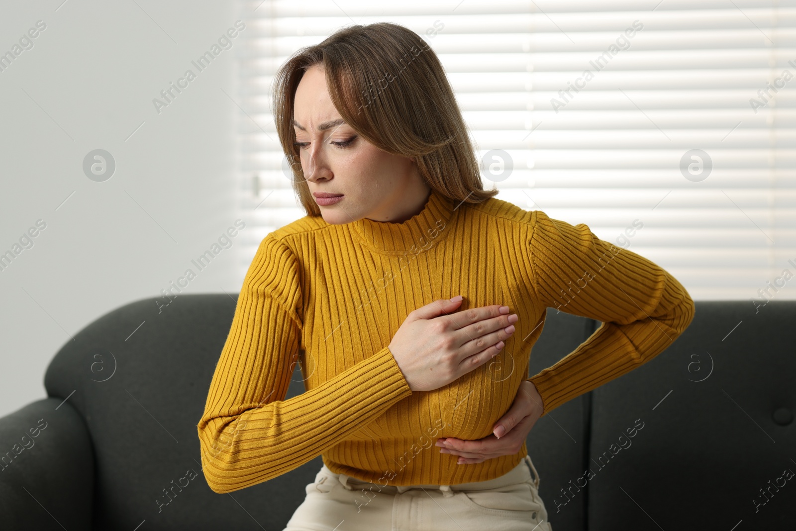 Photo of Mammology. Young woman doing breast self-examination at home