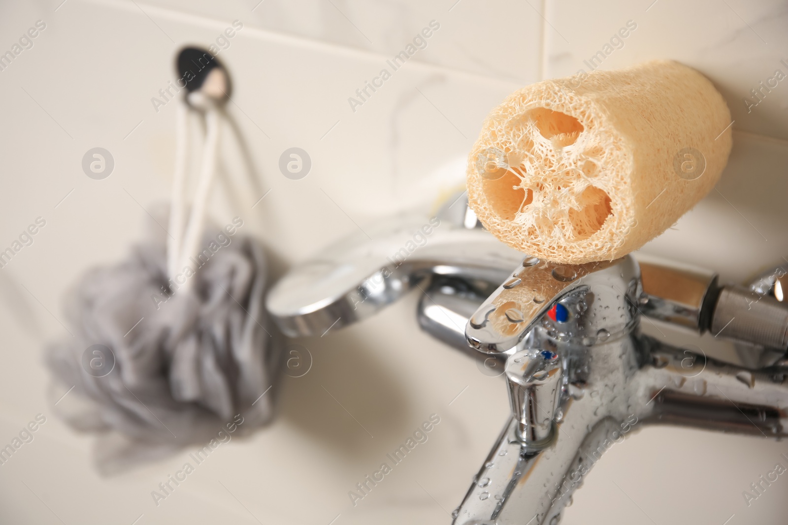 Photo of Grey shower puff and loofah sponge in bathroom, closeup