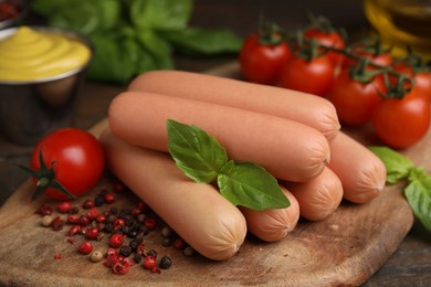 Photo of Delicious boiled sausages, tomatoes, basil and peppercorns on table, closeup