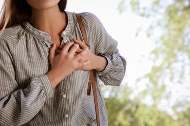 Photo of Young woman having heart attack in park, closeup