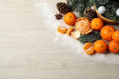 Photo of Flat lay Christmas composition with fresh tangerines on light wooden table. Space for text