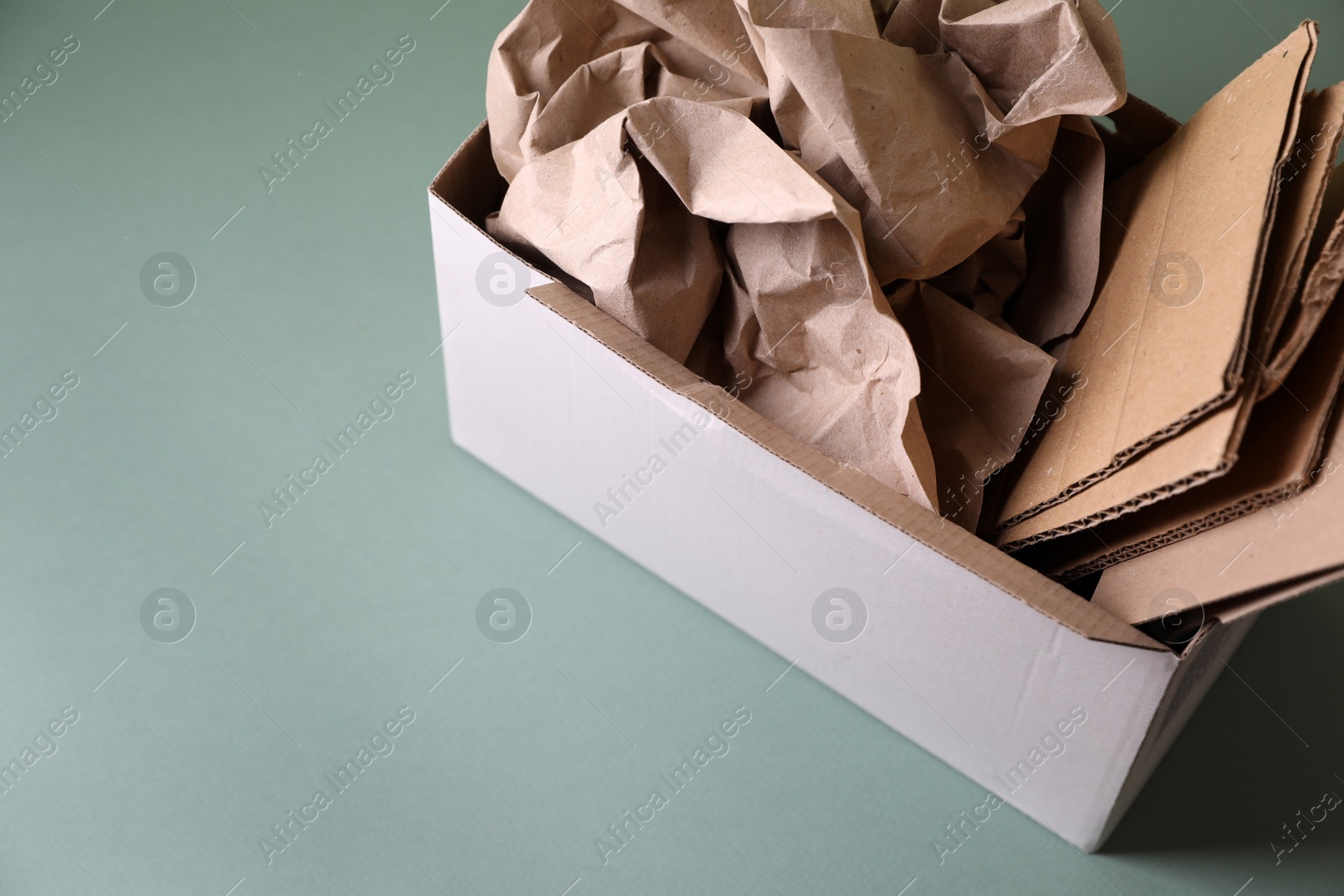 Photo of Box of waste paper on grey table, space for text