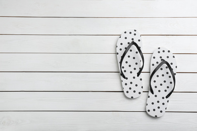 Photo of Stylish flip flops on white wooden background, flat lay. Space for text