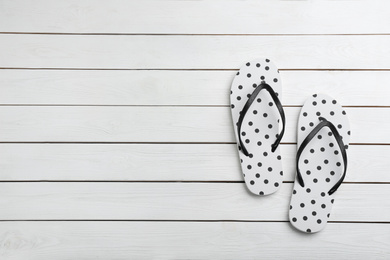 Stylish flip flops on white wooden background, flat lay. Space for text