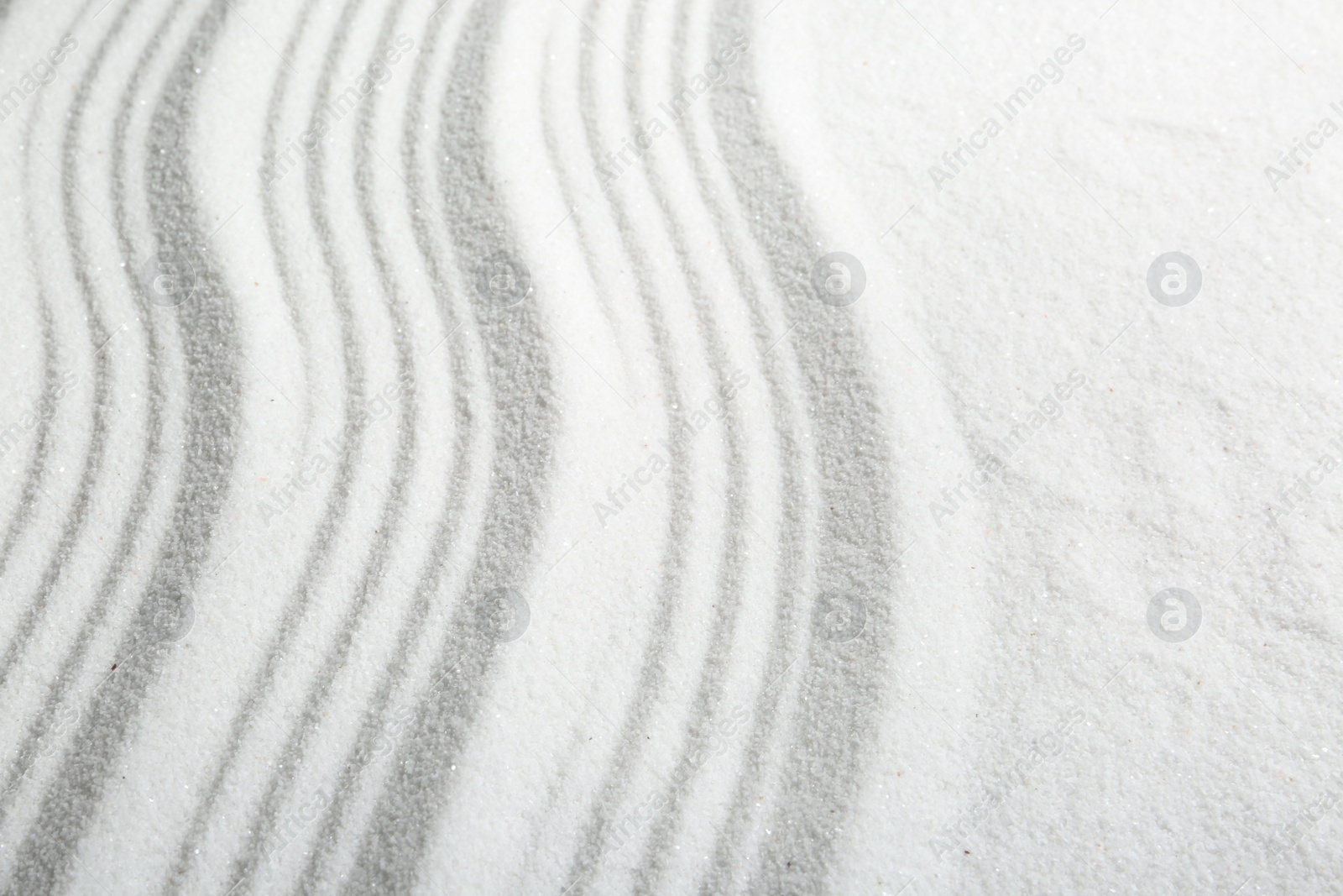 Photo of Zen rock garden. Wave pattern on white sand