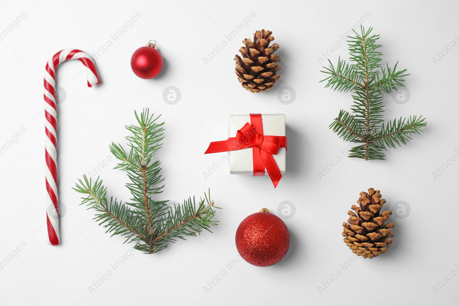 Photo of Composition with Christmas tree branches, festive decor and gift box on white background