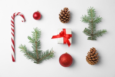 Photo of Composition with Christmas tree branches, festive decor and gift box on white background